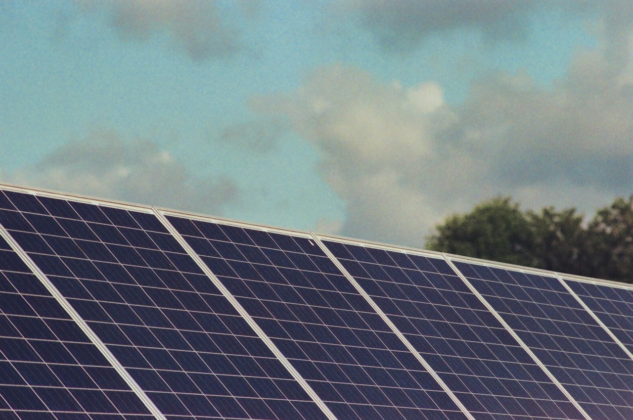 hero-img-01 Photograph of solar panels capturing renewable energy under a blue sky, promoting sustainability and environmental protection.